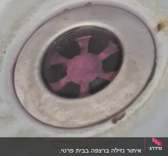 ניקוז כיור עם סימני חלודה סביב הפתח